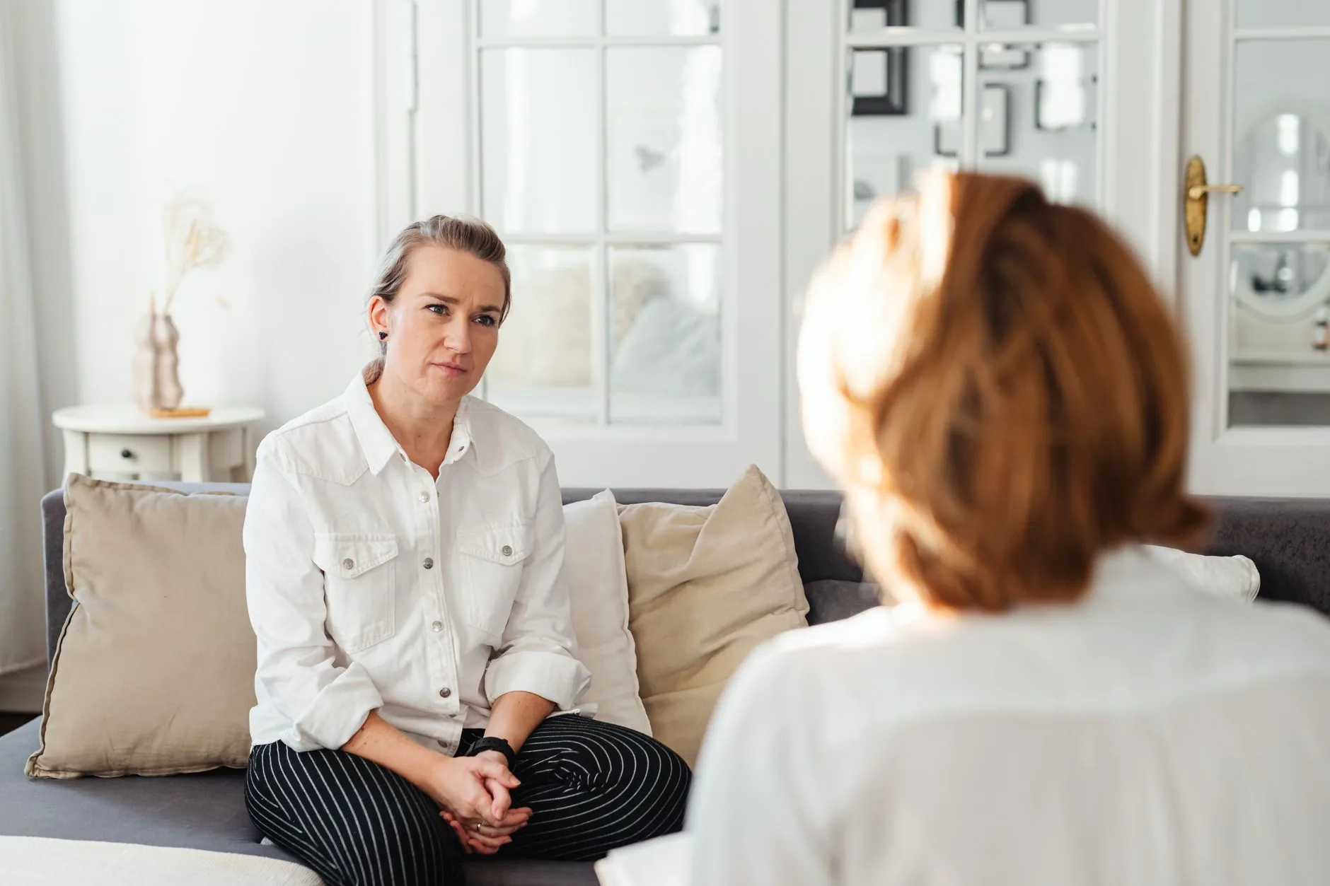 Twee vrouwen in een ontspannen gesprek in een lichte ruimte