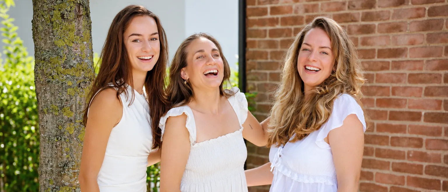Drie vrouwen van Healthy Business Women lachen samen buiten
